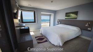 a bedroom with a bed and a view of the ocean at Hotel AATRAC in Mar del Plata