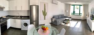 a kitchen and a living room with a table and a couch at Apartamentos Zalabar in Tías