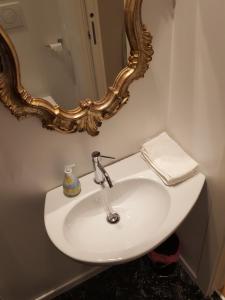 ein weißes Waschbecken im Bad mit Spiegel in der Unterkunft Casa Barzizza in Venedig