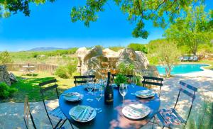 a blue table with wine glasses on it next to a pool at Wild Boar Mountain, Luxury Escape & Stunning Views! in Bédarieux