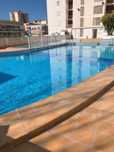 una piscina de agua azul en un edificio en BEACH I, en Gandía