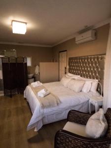 1 dormitorio con 1 cama grande y toallas. en Ville la'Rina, en Ciudad del Cabo