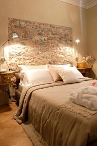a bedroom with a large bed with a stone wall at Residenza D'Epoca -Santa Caterina in Pisa