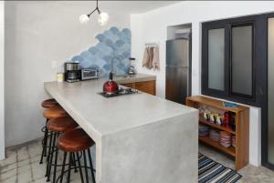 Una cocina con una encimera con taburetes y un refrigerador. en Villa Dorado A, en Sayulita 6 fotos más