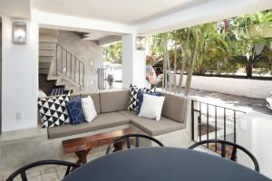 Un porche con un sofá, una mesa y sillas. en Villa Dorado A, en Sayulita