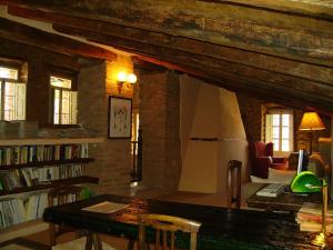 a room with a library with a table and a couch at Hotel Boutique Condes Fúcares in Almadén