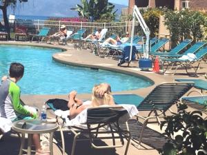 a group of people laying in lawn chairs by a pool at Deluxe Oceanview Maui Studio..New & Updated in Kahana