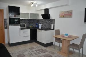 a kitchen with black and white appliances and a table at Ferienwohnung Emil in Immenstadt im Allgäu