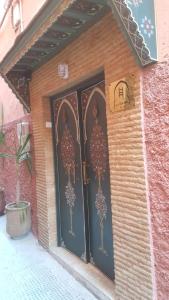a pair of black doors on a brick building at BED SQUARE Hostel in Marrakesh