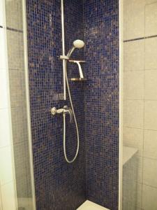 Ferienwohnung preiswert und strandnah في فارنمونده: دش في حمام به بلاط ازرق +10 صور