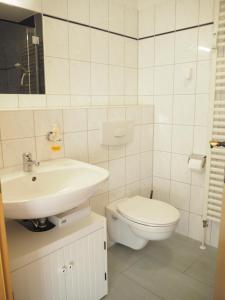 uma casa de banho branca com um WC e um lavatório em Ferienwohnung preiswert und strandnah em Warnemünde