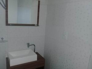 y baño con lavabo blanco y espejo. en Chalé duplex reformado - Fazenda Cantinho en Teresópolis