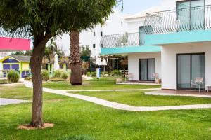 a building with a tree in the grass at Bayside Salgados in Albufeira