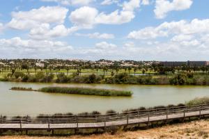 a river with a bridge and a city in the background at Bayside Salgados in Albufeira