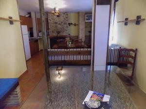 a living room with a glass table and a kitchen at Fuente Del Gamellon in Buenache de la Sierra