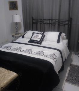 a black and white bed with white pillows on it at Ocean Dreams in Aguada