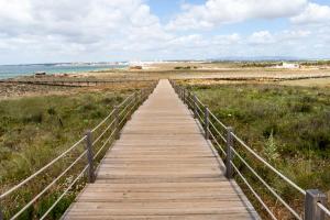 a wooden boardwalk leading to the beach at Bayside Salgados in Albufeira