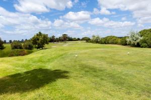 a golf course with a green field with trees at Bayside Salgados in Albufeira