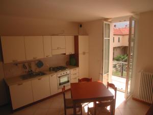 a kitchen with white cabinets and a table and a window at "Il Terrazzo" Apartment in Colico