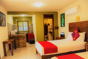 ein Schlafzimmer mit einem Bett und einer Küche darin in der Unterkunft El Roble Nature Hotel & Lagoon in Bacalar