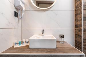 a bathroom with a white sink and a mirror at Oasis in Sarti