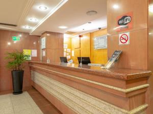 a lobby of a hotel with a reception counter at Real Castilha Hotel in Sao Paulo