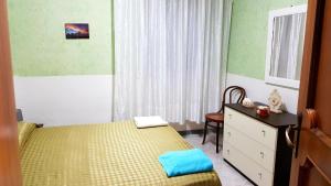 1 dormitorio con 1 cama amarilla, vestidor y ventana en Casa degli Ulivi, en Gela