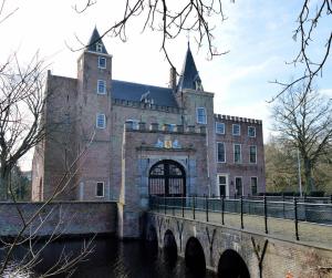 a large brick building with a bridge in front of it at t Laege Uus in Burgh Haamstede