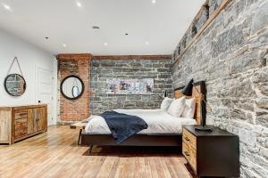 1 dormitorio con pared de ladrillo y 1 cama en una habitación en Bakan- Saint Francois Xavier, en Montreal