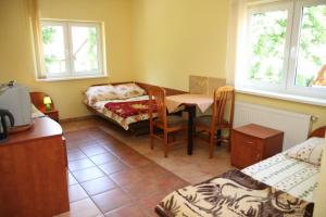 a room with a table and a bed and a table and chairs at Zacisze Konopnickiej in Pobierowo