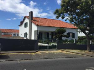 Casa blanca con techo rojo y valla en Vivenda Garcia B&B en Relva