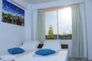 una camera da letto con due letti e una grande finestra di Sigiriya Water Guest & View Point Restaurant a Sigiriya