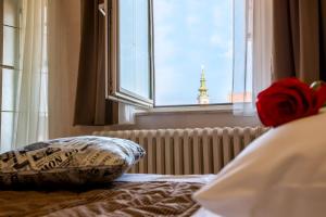 a bed with two pillows in a bedroom with a window at Hotel Fontana in Novi Sad