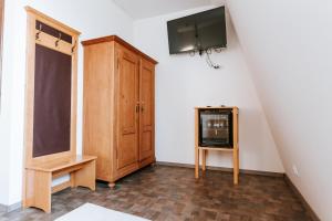 a room with a tv and a wooden cabinet at Conacul Nagy in Coşeni