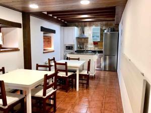 a kitchen with tables and chairs and a refrigerator at La Posada de Abanillas in Abanillas