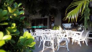 a group of white chairs and tables on a patio at Canoas Parque Hotel in Canoas