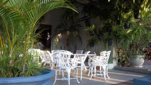 Canoas Parque Hotel في كانواس: مجموعة من الكراسي البيضاء والطاولات والنباتات