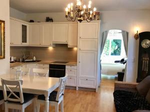 una cucina con mobili bianchi e un tavolo con sedie di Traumhafte Wohnung auf Pferde Ranch ad Aich