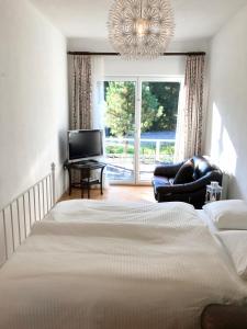 een slaapkamer met een bed, een stoel en een kroonluchter bij Traumhafte Wohnung auf Pferde Ranch in Aich