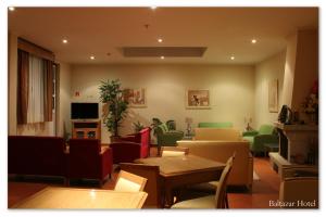 Una sala de estar con mesas y sillas y un sofá. en Baltazar Hotel, en Gerês