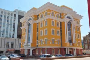 un edificio amarillo con coches estacionados frente a él en Meridian, en Saransk