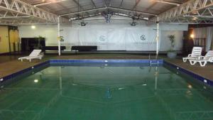 a swimming pool in a large building with a stage at Canoas Parque Hotel in Canoas