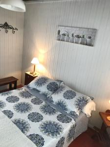 a bedroom with a bed with a blue and white quilt at Conaguademar in La Paloma