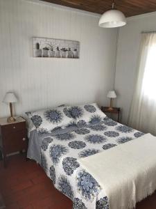 1 dormitorio con 1 cama con manta azul y blanca en Conaguademar, en La Paloma