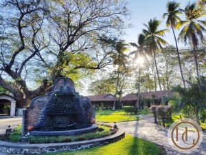 a monument in the middle of a park with palm trees at Hotel Hacienda Gualiqueme in Choluteca
