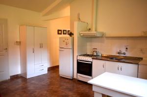 a kitchen with a white refrigerator and a stove at Hosteria Suyana in San Salvador de Jujuy