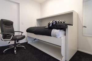a bedroom with a bed and a chair and a desk at Aqua-Heights Apartment in Nelson
