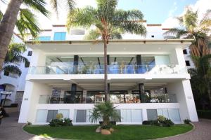 a building with palm trees in front of it at Hotel Gran Plaza & Convention Center in Guanajuato