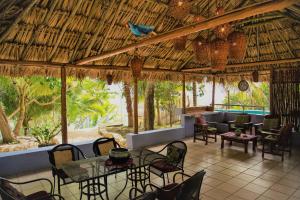 a restaurant with a table and chairs and a bird on the ceiling at El Roble Nature Hotel & Lagoon in Bacalar