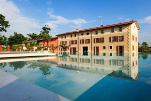 a building with its reflection in a pool of water at Belvivere Suites in Sona